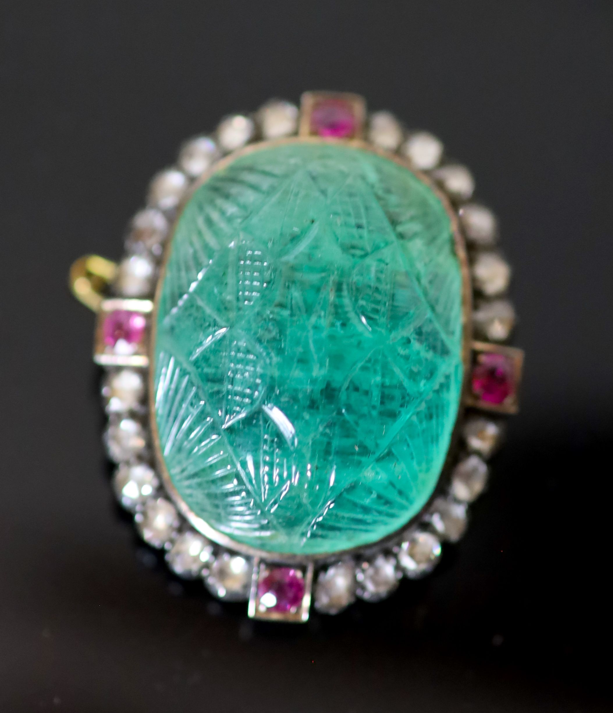 A late 19th century gold and silver, carved emerald, four stone ruby and twenty four rose cut diamond set oval brooch,
